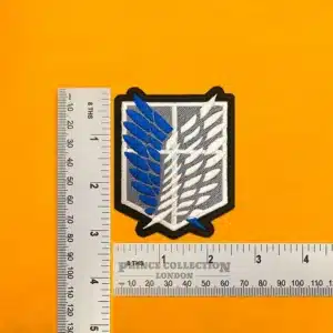 Embroidered Survey Corps wings beside measurement ruler