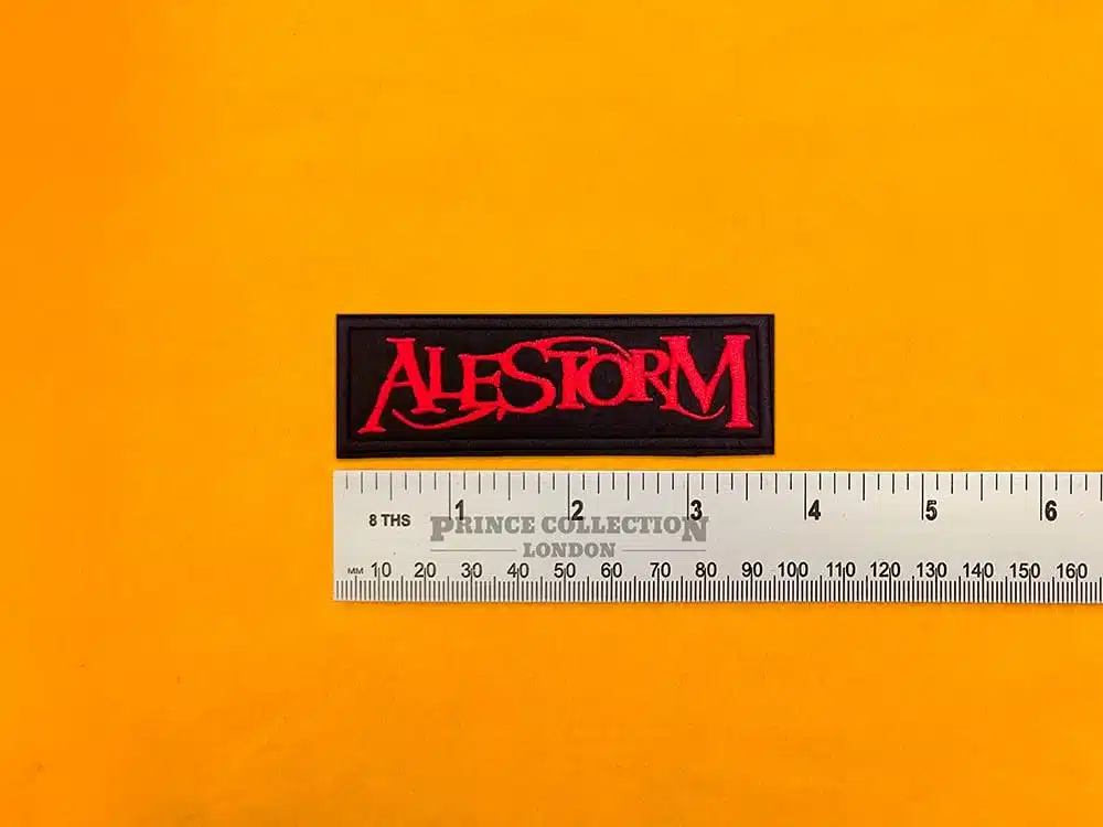 Embroidered Alestorm band design beside measurement ruler