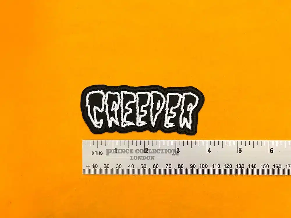 Embroidered Creeper logo beside measurement ruler