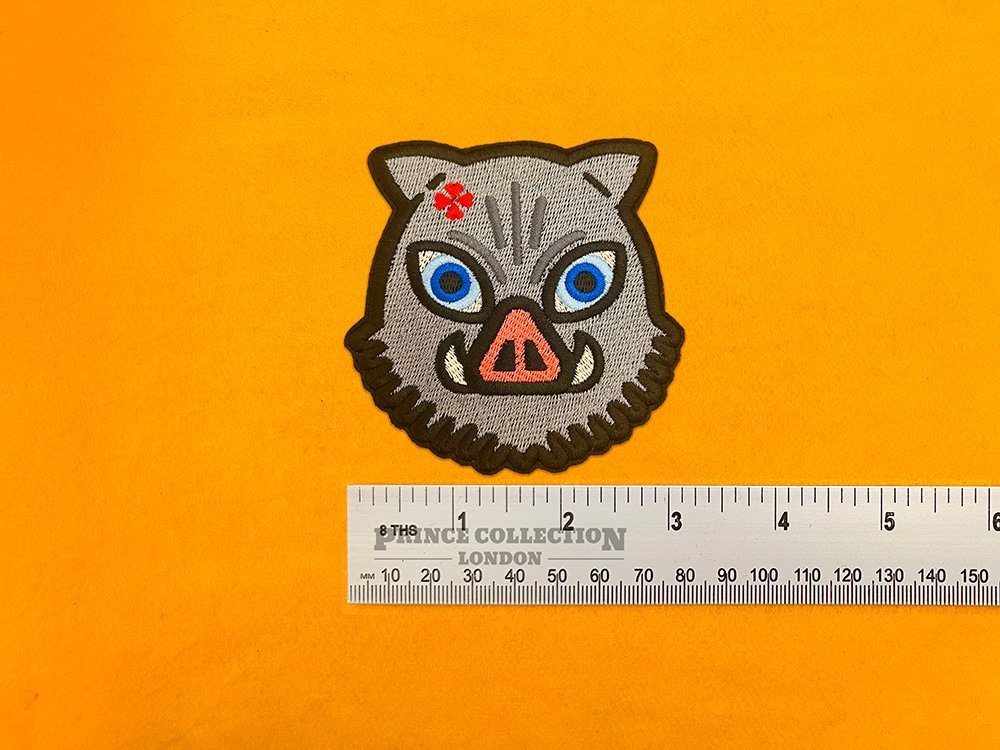 Embroidered Inosuke anime design beside measurement ruler