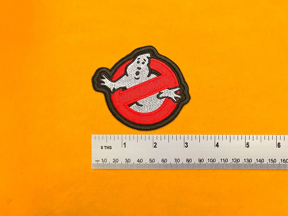 Embroidered Ghostbusters design beside measurement ruler