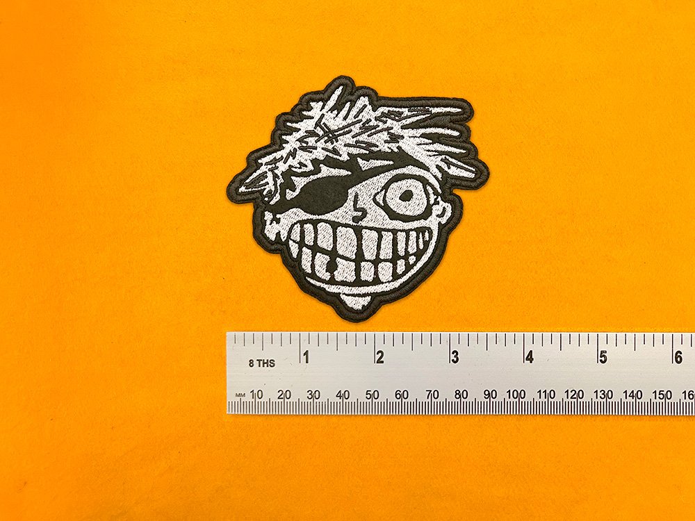 Embroidered Green Day design beside measurement ruler