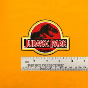 Embroidered dinosaur logo beside measurement ruler