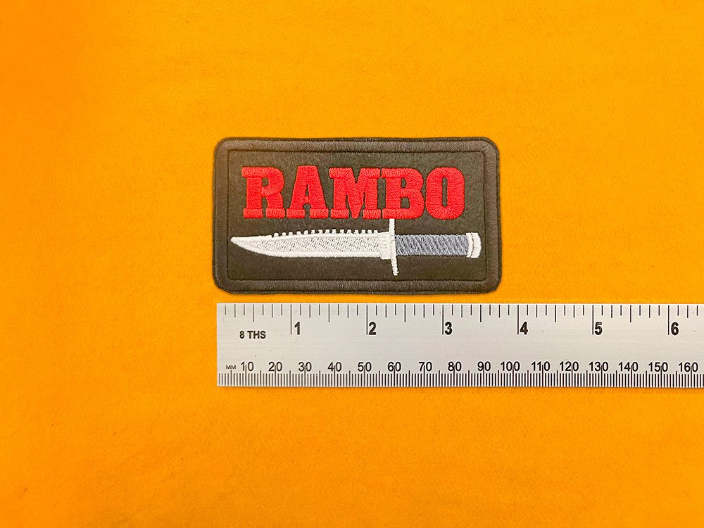 Embroidered Rambo design beside measurement ruler