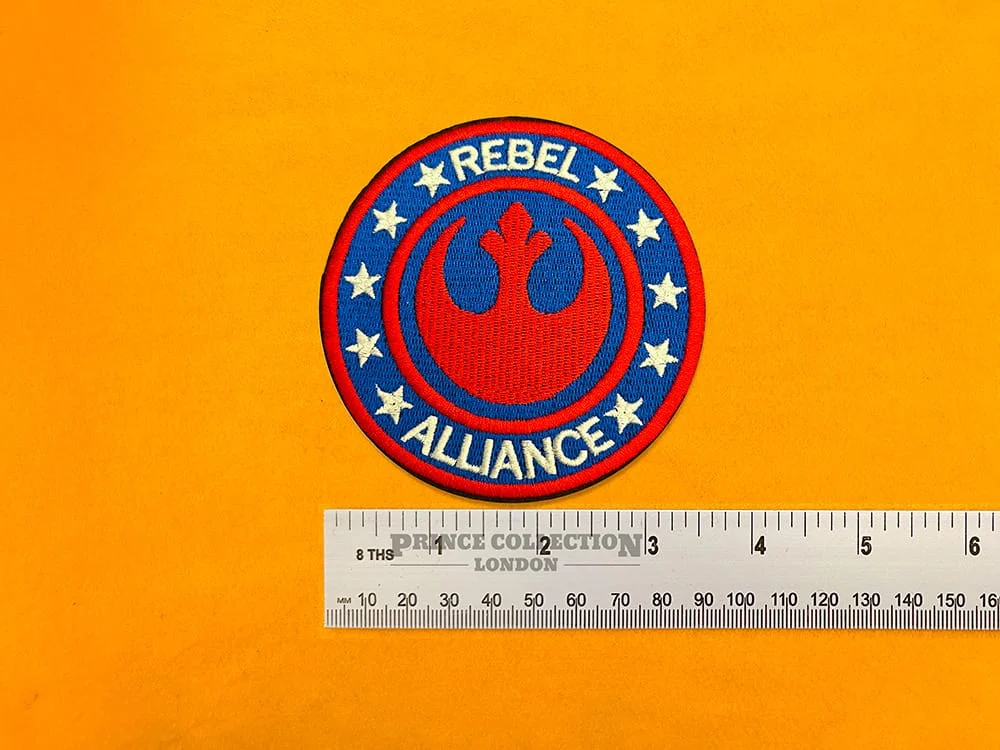 Embroidered Rebel Alliance symbol beside measurement ruler