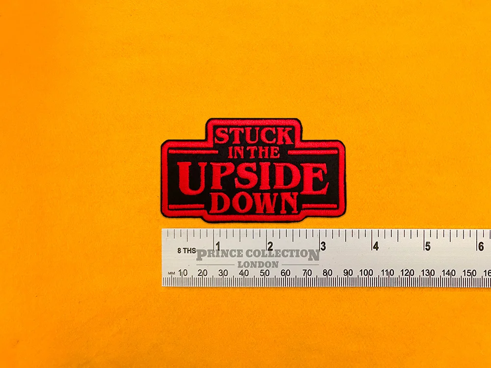 Embroidered Upside Down design beside measurement ruler