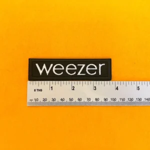 Weezer embroidered logo patch beside measurement ruler