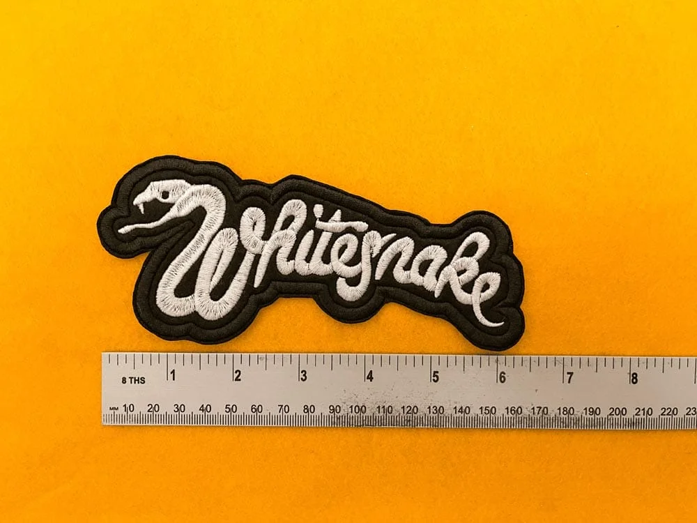 Whitesnake embroidered band patch beside measurement ruler