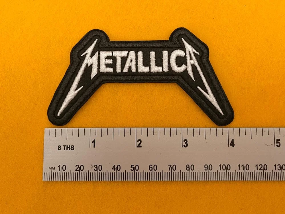 Embroidered Metallica design beside measurement ruler