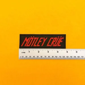 Embroidered Mötley Crüe design beside measurement ruler
