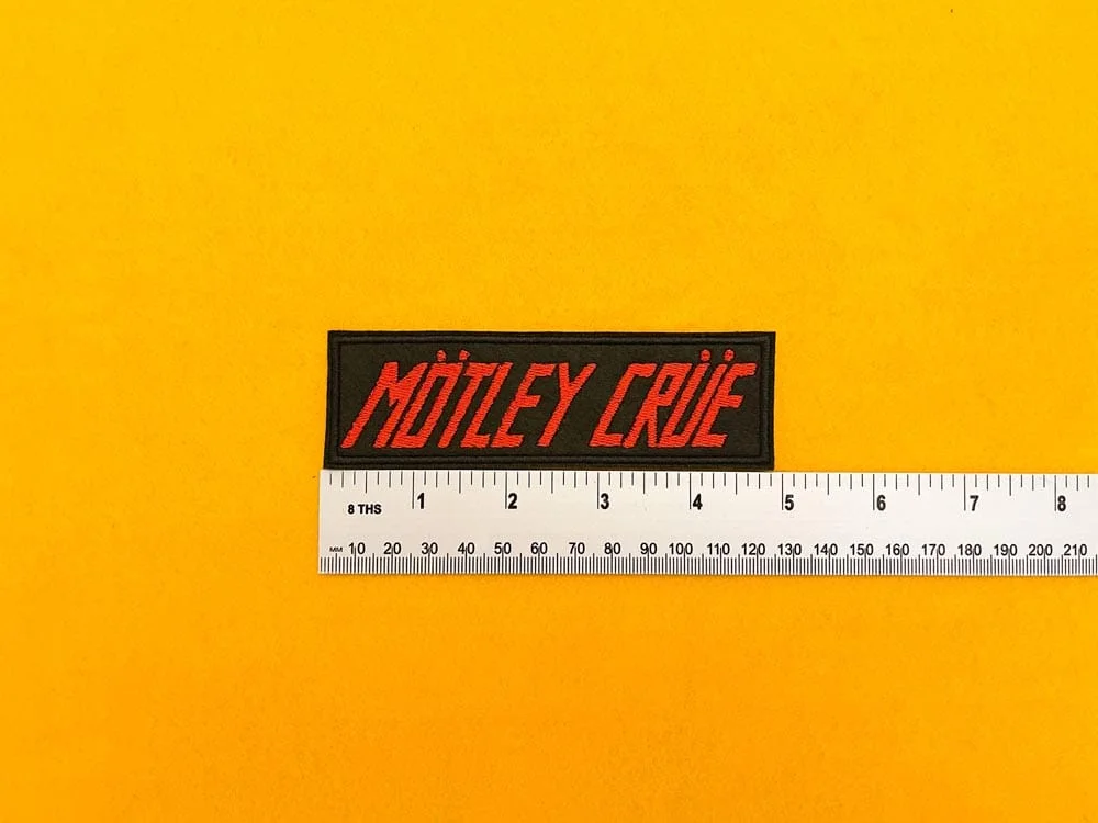 Embroidered Mötley Crüe design beside measurement ruler