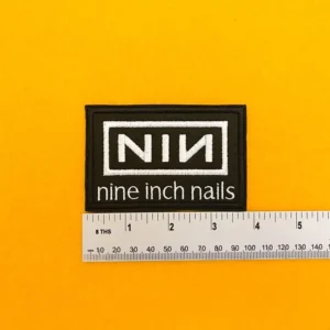 Embroidered Nine Inch Nails design beside measurement ruler