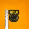Embroidered Nirvana design beside measurement ruler
