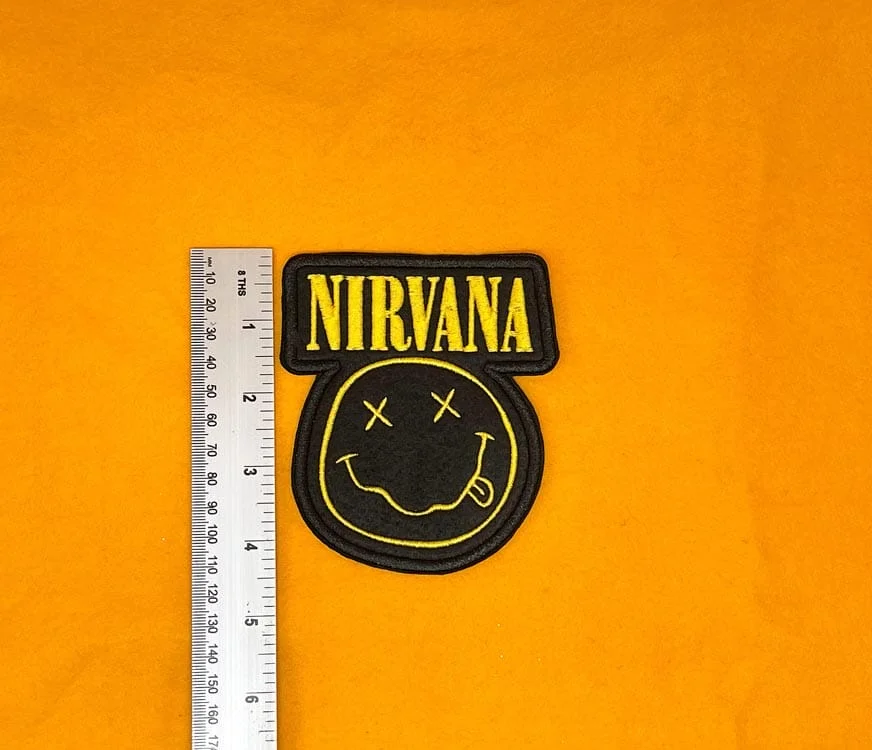Embroidered Nirvana design beside measurement ruler