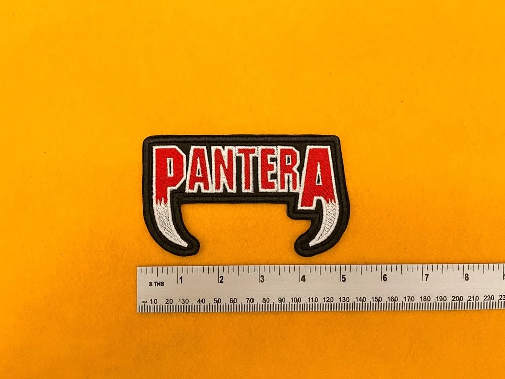Embroidered Pantera design beside measurement ruler