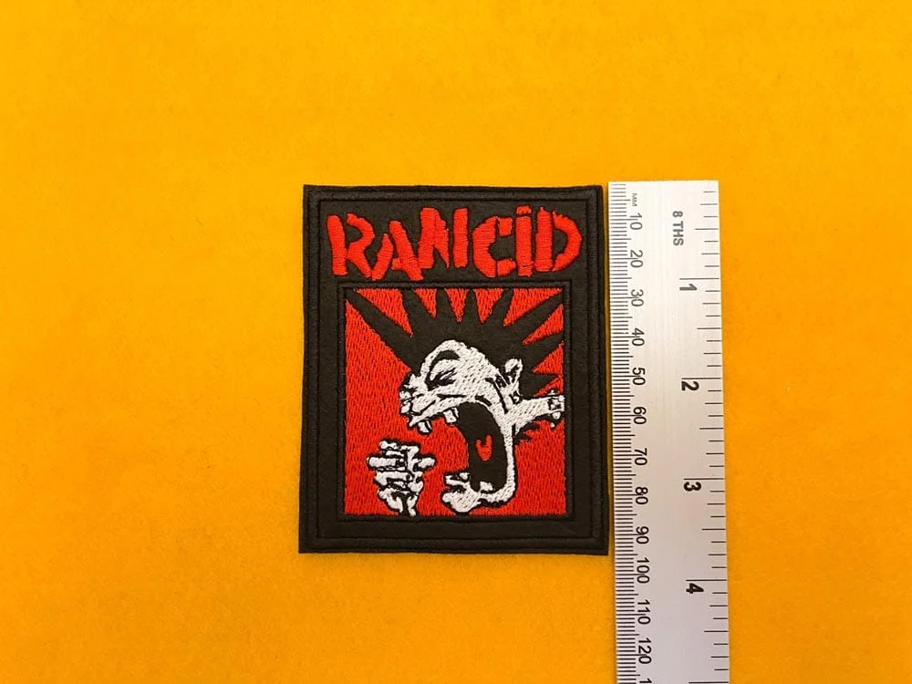 Embroidered Rancid design beside measurement ruler